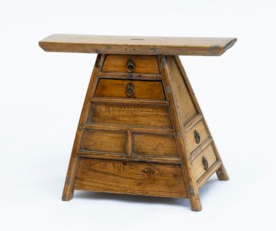 une petite table en bois surmontée de tiroirs
