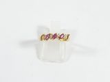 gros plan d'une bague en or avec une pierre rose