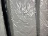 de nombreux matelas emballés dans du plastique dans un entrepôt