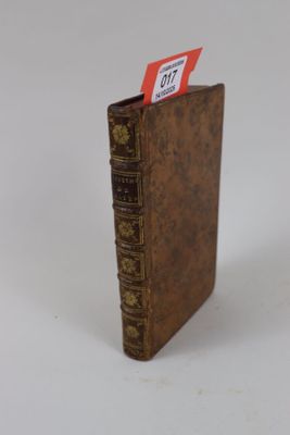 un petit livre marron sur lequel est accrochée une étiquette rouge