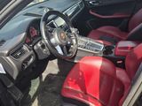 l'intérieur d'une voiture avec des sièges en cuir rouge et un volant