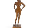 wooden sculpture of a woman standing on a wooden base