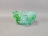 translucent green glass bowl on a white surface with a white background