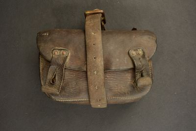 a brown leather bag with two handles on a gray surface