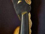 a black and gold sculpture of a woman ' s face on a black background