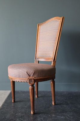 une image représentant une chaise avec un coussin posé dessus, dans une pièce