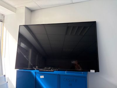 un grand téléviseur à écran plat fixé au mur dans une pièce