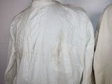 pair of men ' s white shirts hanging on a white wall