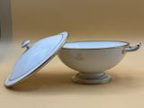 a white bowl with a lid sitting on a table