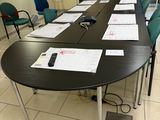 une longue table sur laquelle sont posés plusieurs documents, dans une pièce