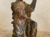 une statue représentant une femme assise sur une chaise