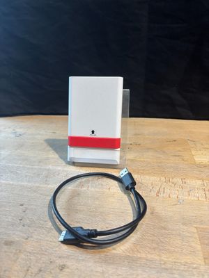 a white box with a red stripe on it sitting on a wooden table