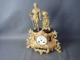 une horloge en or surmontée d'une statue