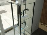 a glass display case with a faucet in it