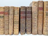 many old books lined up on a shelf together