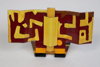 une sculpture rouge et jaune sur une surface blanche