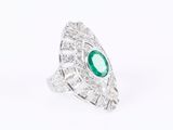 a close up of a ring with a green stone surrounded by diamonds