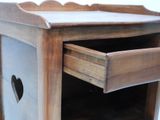 a wooden cabinet with a drawer and a heart on it