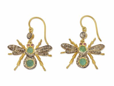 une photo d'une paire de boucles d'oreilles en or ornées de pierres vertes et blanches