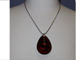 une photo d'un collier orné d'un pendentif rouge en forme de larme