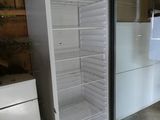 a refrigerator and freezer in a room with wood walls