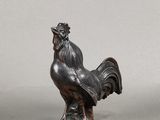 deux figurines représentant un coq posées sur une table