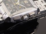 a silver watch with a black face on a black surface