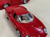 two red toy cars sitting next to each other on a white surface