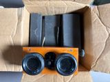 two binoculars sitting in a cardboard box on a table