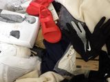 a pile of clothes that is sitting on a bed