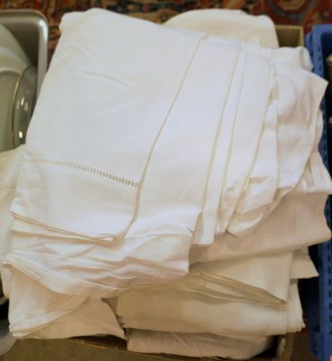 a pile of folded white sheets in a blue container
