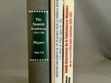 trois livres posés l'un à côté de l'autre sur une table