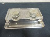 a clear glass tray with two candles on top of it