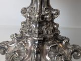 an antique silver plate with a bird on top of it