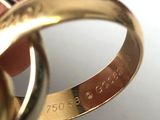 someone is holding two gold wedding rings in their hand