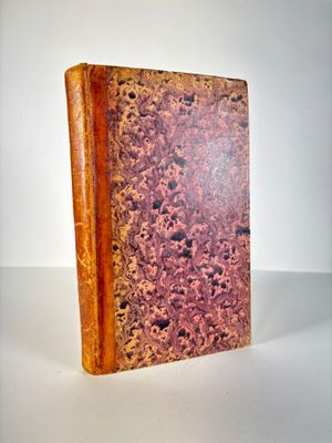 an old book sitting on top of a white table next to a white wall