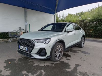 une Audi QX blanche garée devant un garage