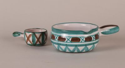 two pieces of pottery sitting on top of a table next to each other
