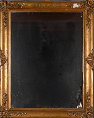 un miroir à cadre doré posé sur une table près d'un mur