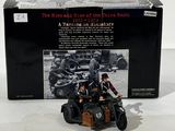 image d'une moto jouet dans son emballage, avec deux hommes à son bord