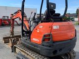 a close up of a small excavator parked in a parking lot