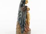figurine of a woman holding a child on a rock