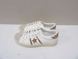 white sneakers with gold glitters on them on a white surface