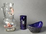 two vases and a bowl sitting next to each other on a table