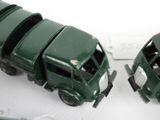 two green toy trucks sitting next to each other on a table