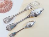 four silver spoons and two silver spoons on a table