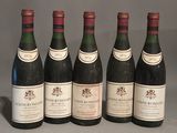 six bottles of wine are lined up in a row on a table