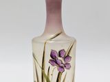 vase violet et blanc orné de fleurs violettes sur un fond blanc