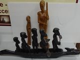 carvings of people in a boat on a table in a room