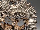 a close up of a silver crown with a bird on it